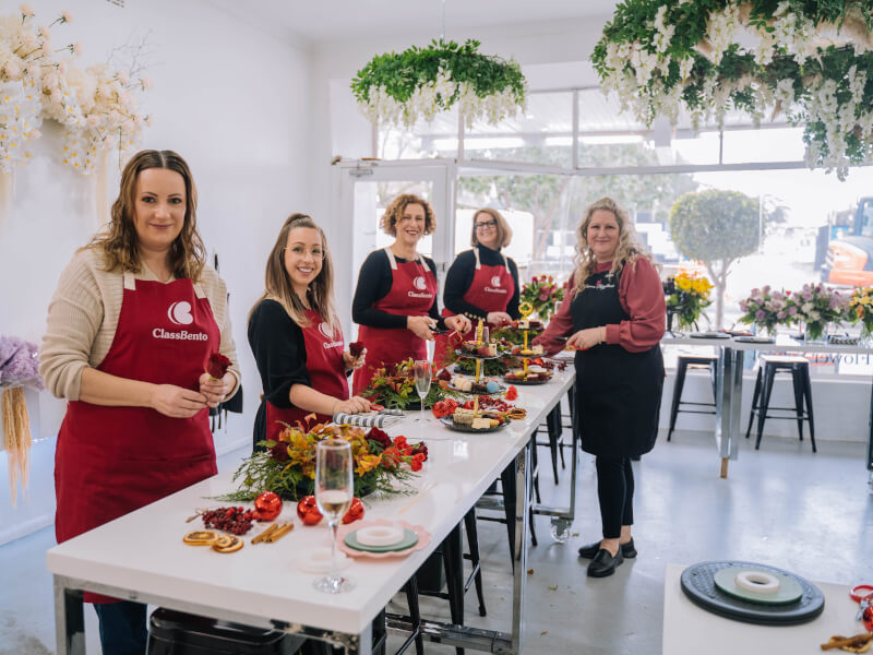 Students with teacher smiling at a Christmas floristry class